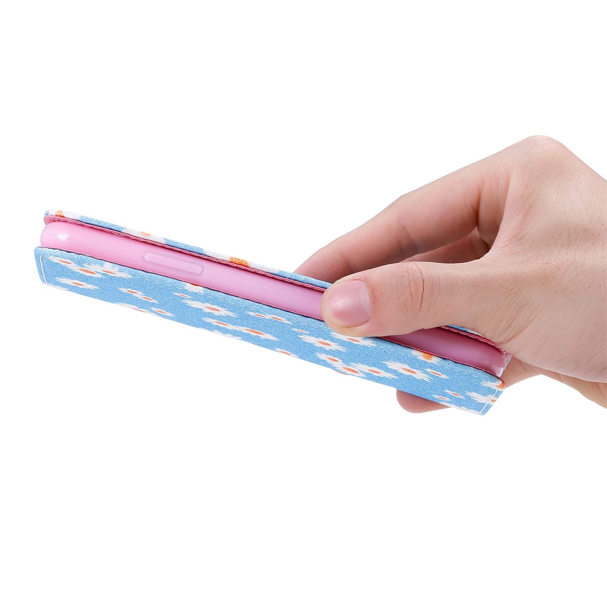 Hand, die ein Telefon in einer gemusterten blau-rosa Hülle hält. Rosa Telefon darin.