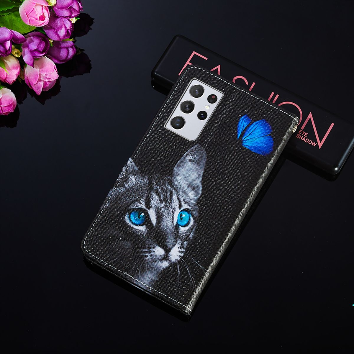 Schwarze Handyhülle mit Katzen-Gesicht und blauen Augen. Auf der rechten Seite ein blauer Schmetterling.