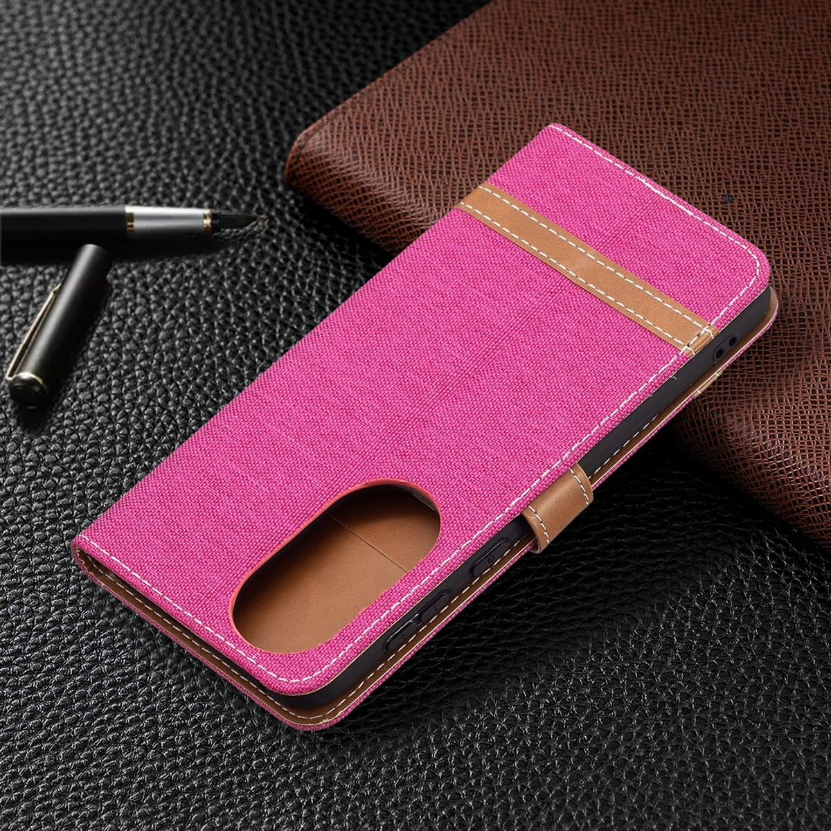 Rosafarbene Handyhülle mit zweifarbigem Design, geschlossen. Auf dunkler Oberfläche.