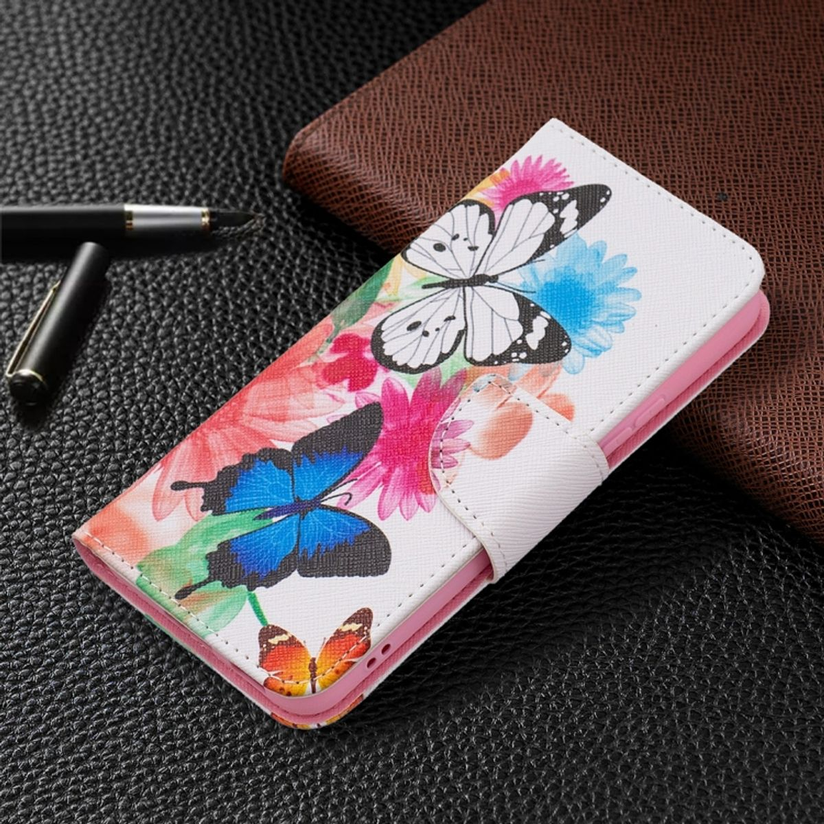 Weiße Handyhülle mit Schmetterlingen und Blumen, offen. Rosa Telefonhalterung innen.