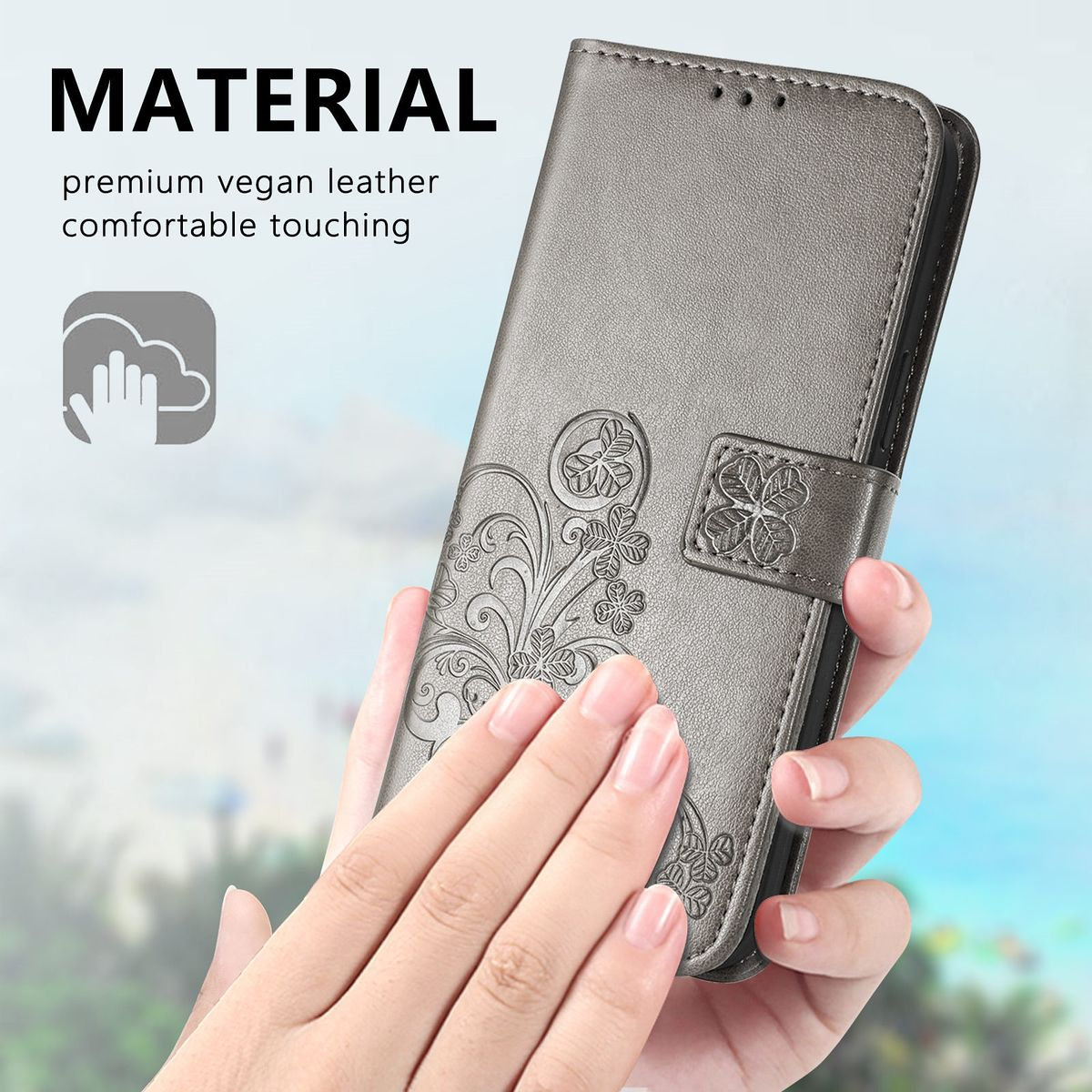 Graue Handyhülle mit floralem Design. Eine Hand hält die Hülle und zeigt die komplizierten Details.