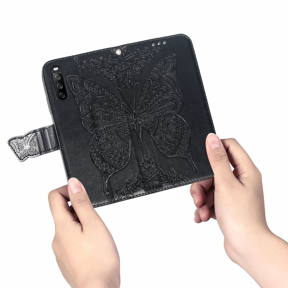 Schwarze Handyhülle mit Schmetterlingsdesign, von Händen gehalten. Der Schmetterling ist mittig.