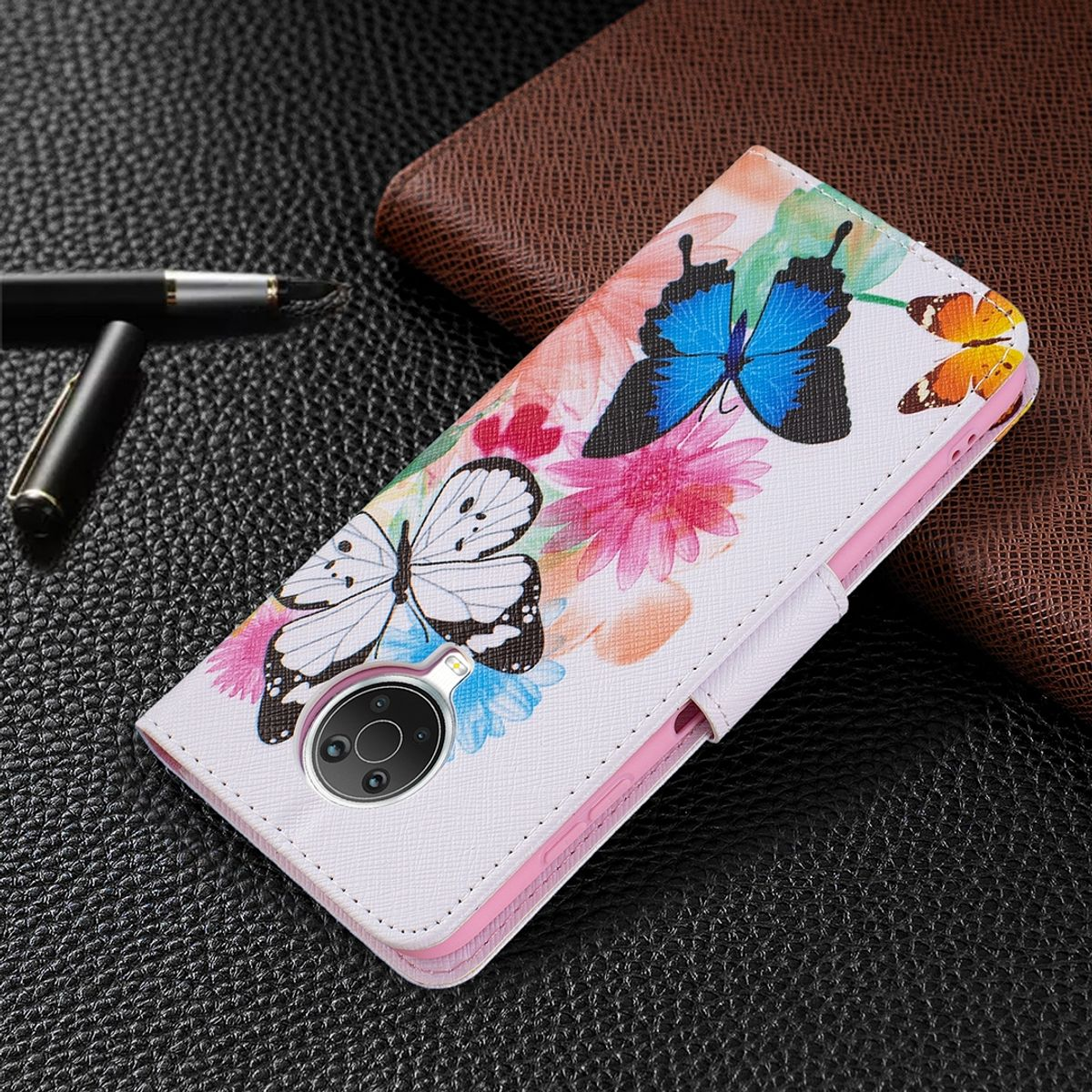 Weiße Handy-Geldbörsenhülle mit Schmetterlingen und Blumen. Die Hülle ist geöffnet und liegt auf einer dunklen Oberfläche.