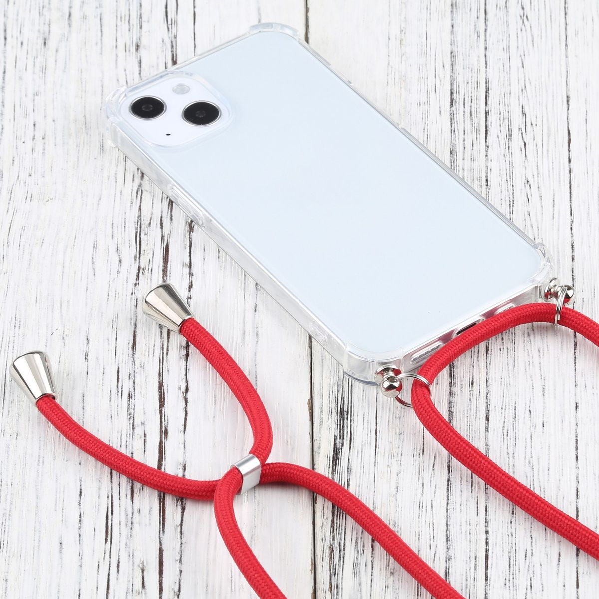 Weißes iPhone mit roter Kordel. Das Telefon ist in einer durchsichtigen Hülle. Liegt auf Holz.