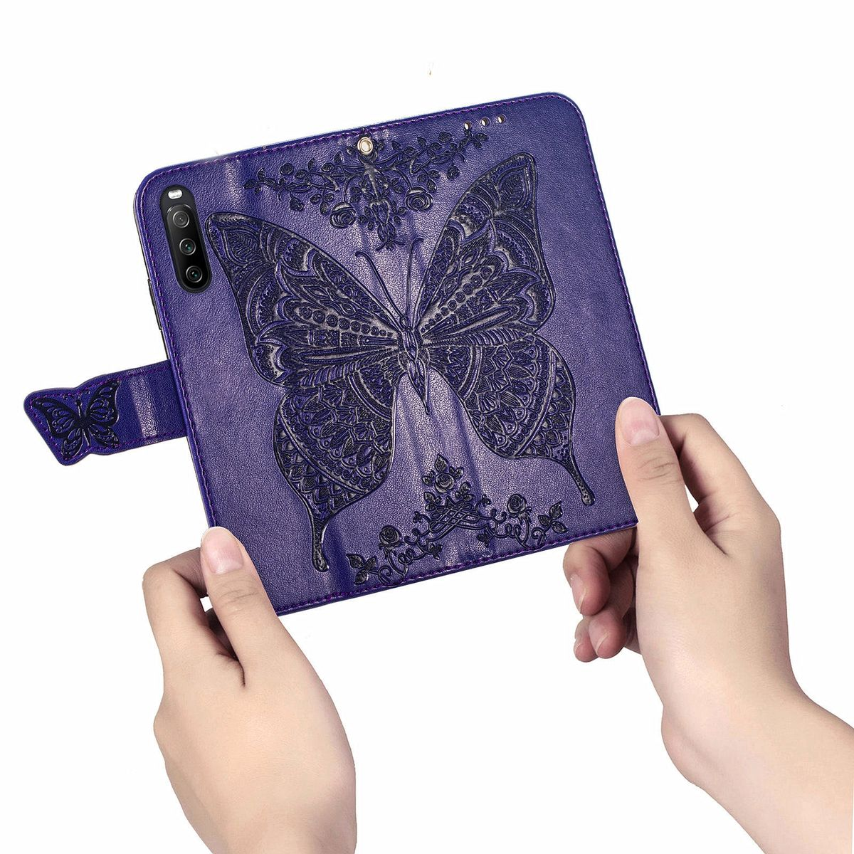 Lila Handyhülle mit Schmetterlingsdesign, geöffnet und abgewinkelt. Hände halten das Telefon.