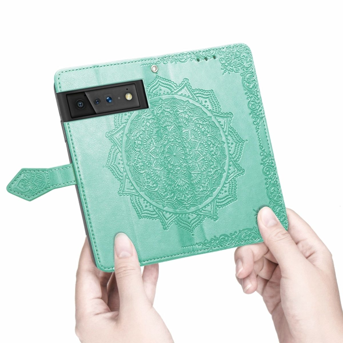 Grüne Handyhülle mit Mandala-Design, gehalten von Händen. Heller Hintergrund.