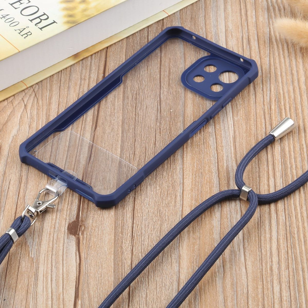 Blaue Handyhülle mit blauem Lanyard. Handyhülle ist klar und auf Holzgrund.