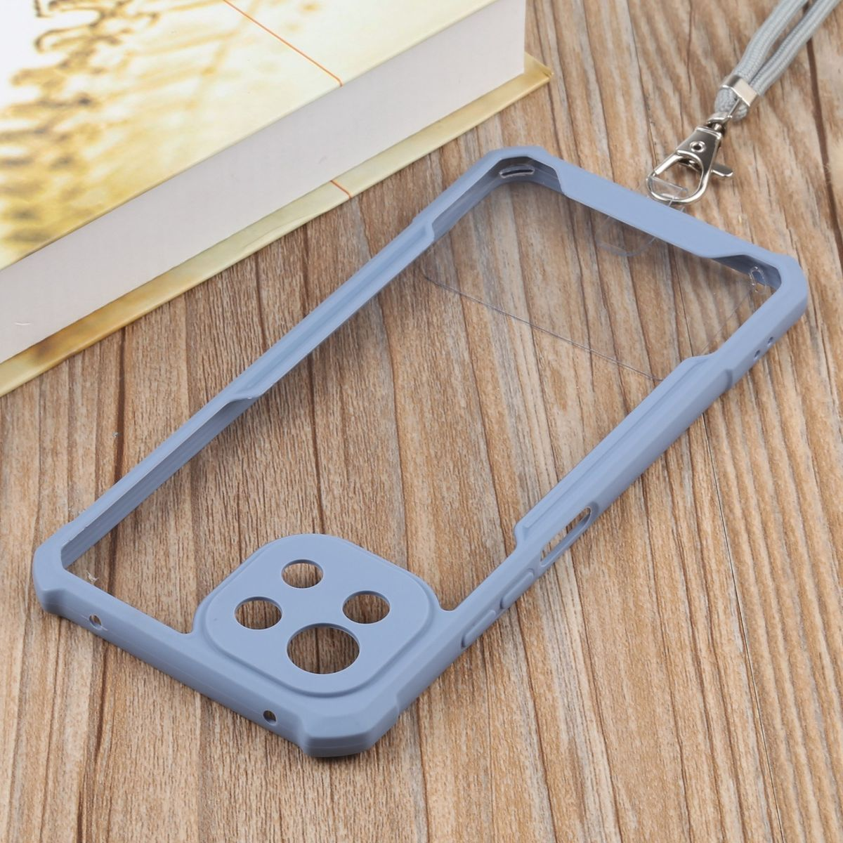 Graue Handyhülle mit transparentem Mittelteil. Mit Lanyard auf Holz.