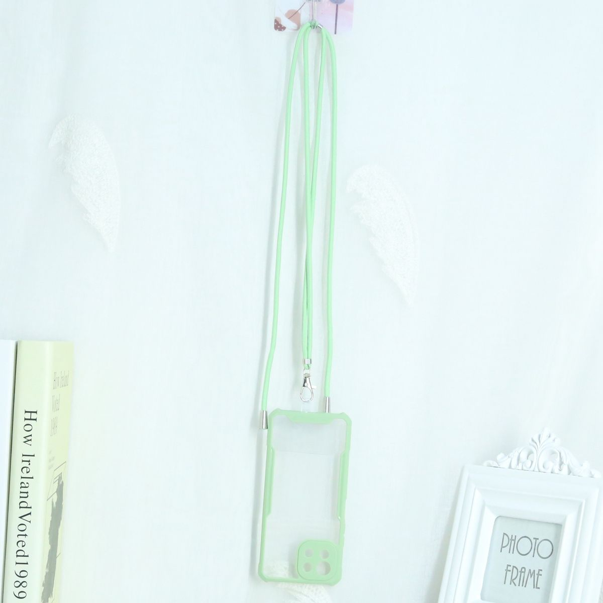 Transparente Handyhülle mit grünem Lanyard. Handyhülle und Zubehör auf weißem Hintergrund.
