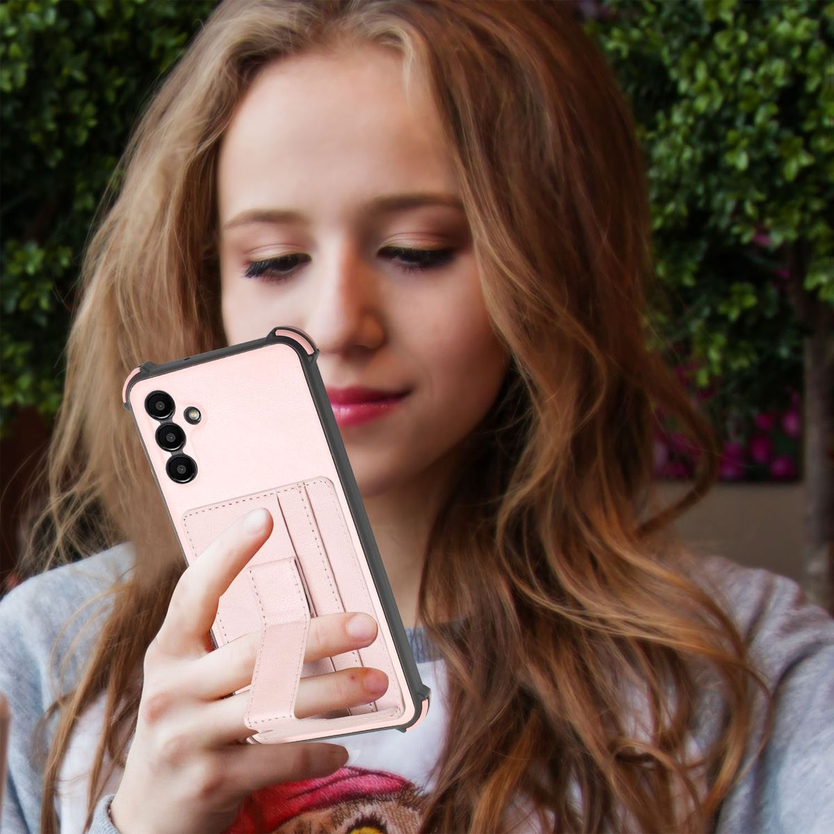 Frau hält rosa Handyhülle mit Telefon. Hülle mit Kartenfach und Ständer.