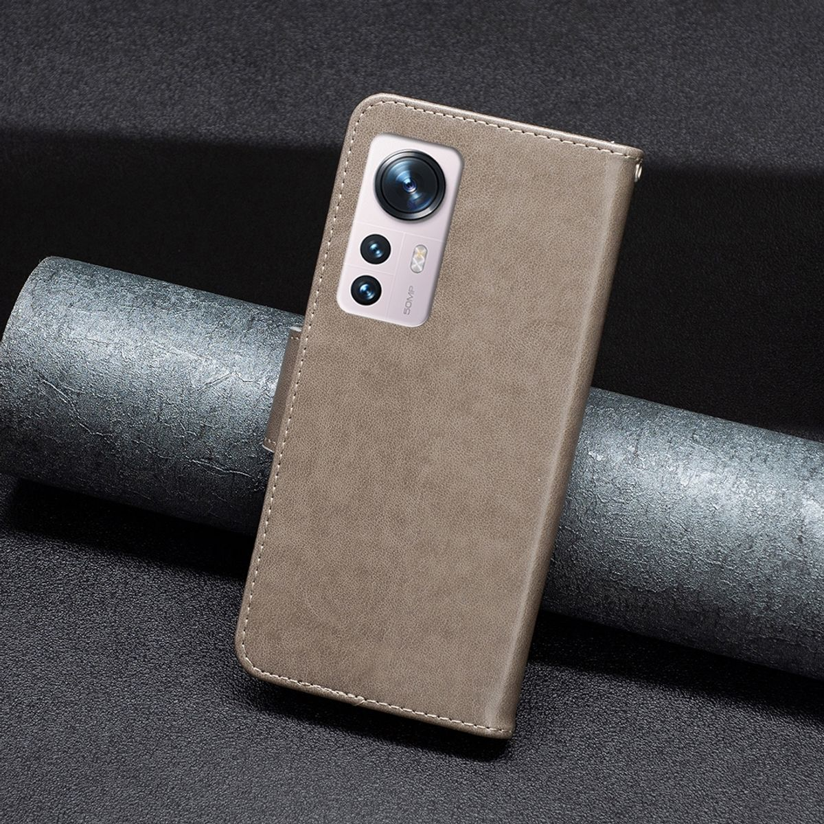 Braune Leder-Handyhülle mit Telefon darin, auf dunkelgrauer Oberfläche.