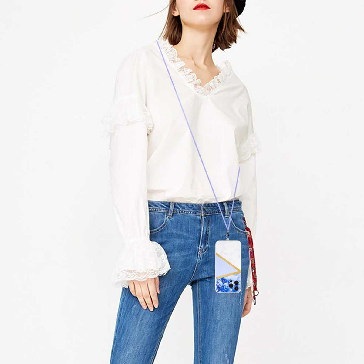 Frau mit floraler Handyhülle an einem Umhängeband. Jeans, weißes Hemd. Holztisch.