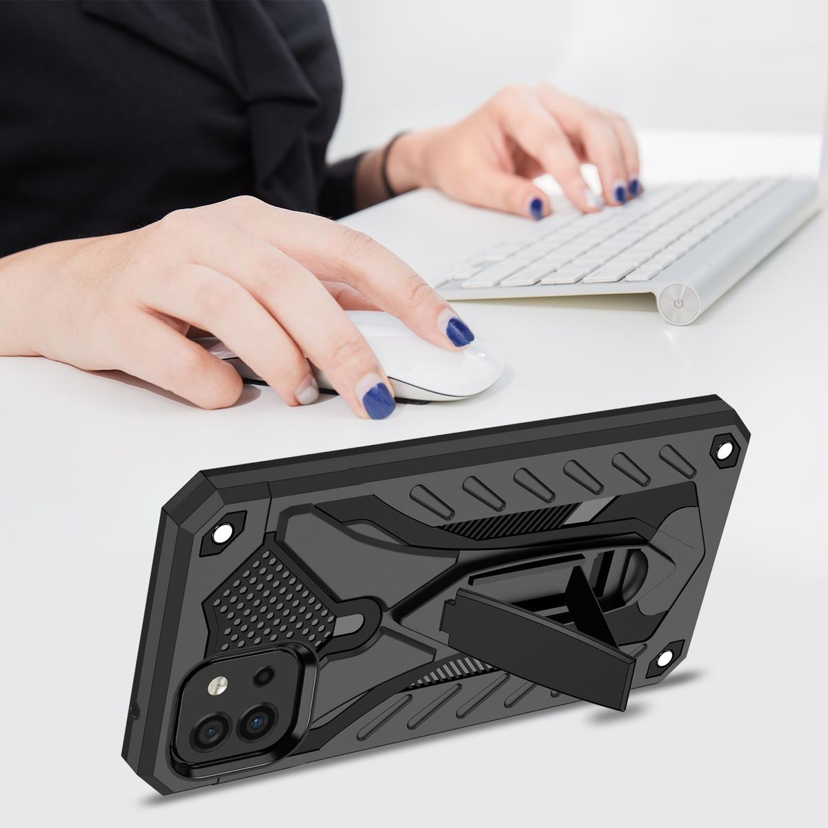 Eine schwarze Handyhülle mit Ständer liegt auf einem weißen Schreibtisch. Im Hintergrund sind Hände einer Person zu sehen.
