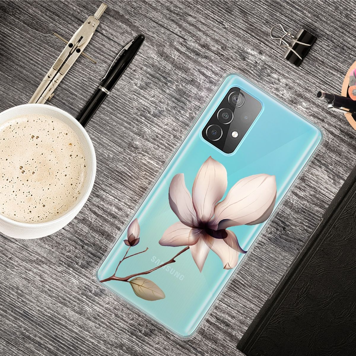 Telefon auf Tisch mit Blumendesign auf Hülle. Kaffeetasse, Stifte und Zubehör vorhanden.
