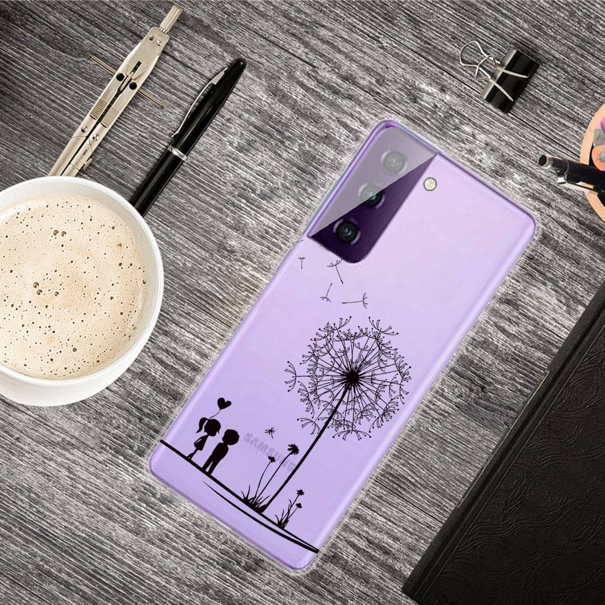 Lila Handyhülle mit Löwenzahndesign, auf einem Schreibtisch mit Kaffee und Stiften.