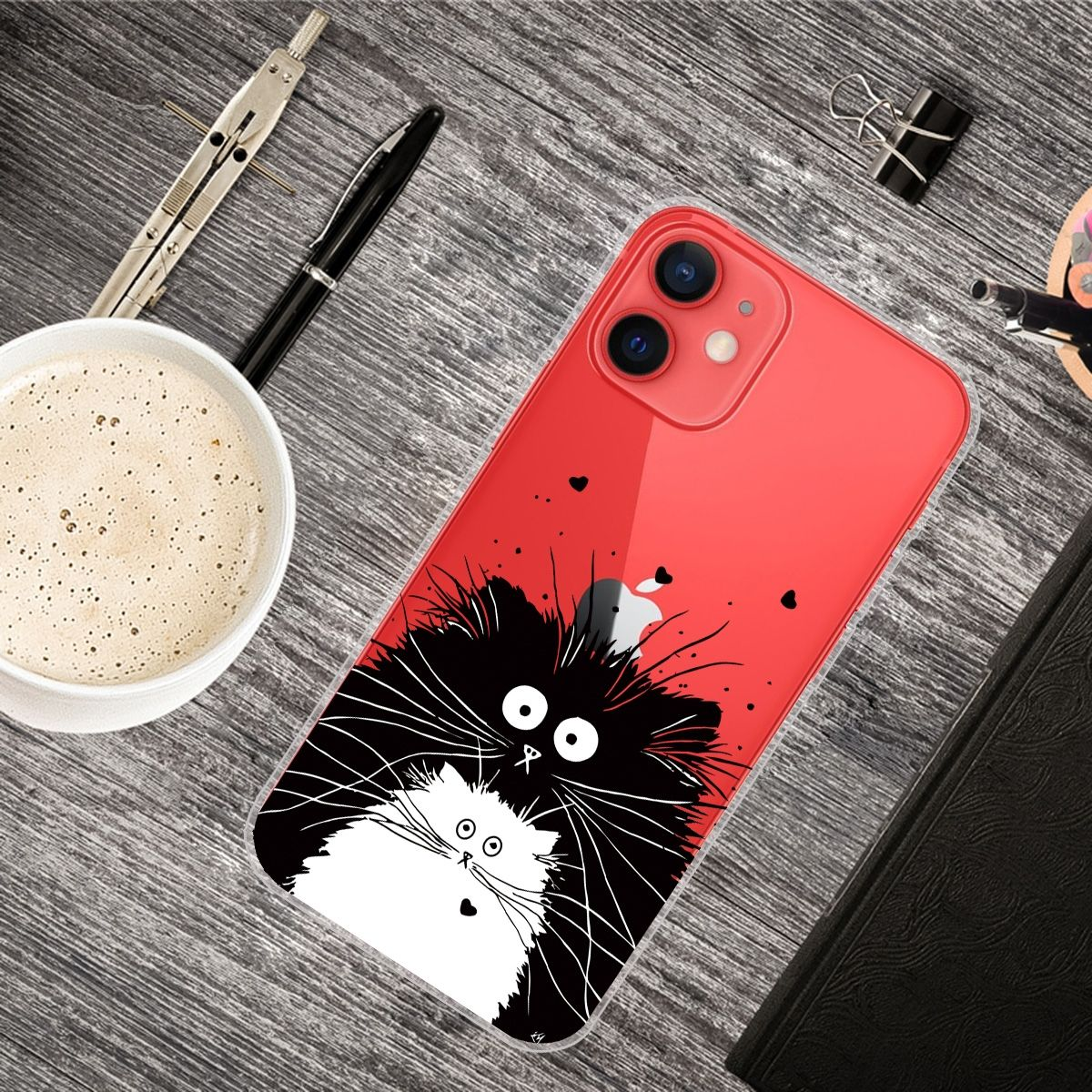 Handyhülle mit einem schwarz-weißen Katzenmuster auf einem Holztisch mit Bürobedarf.