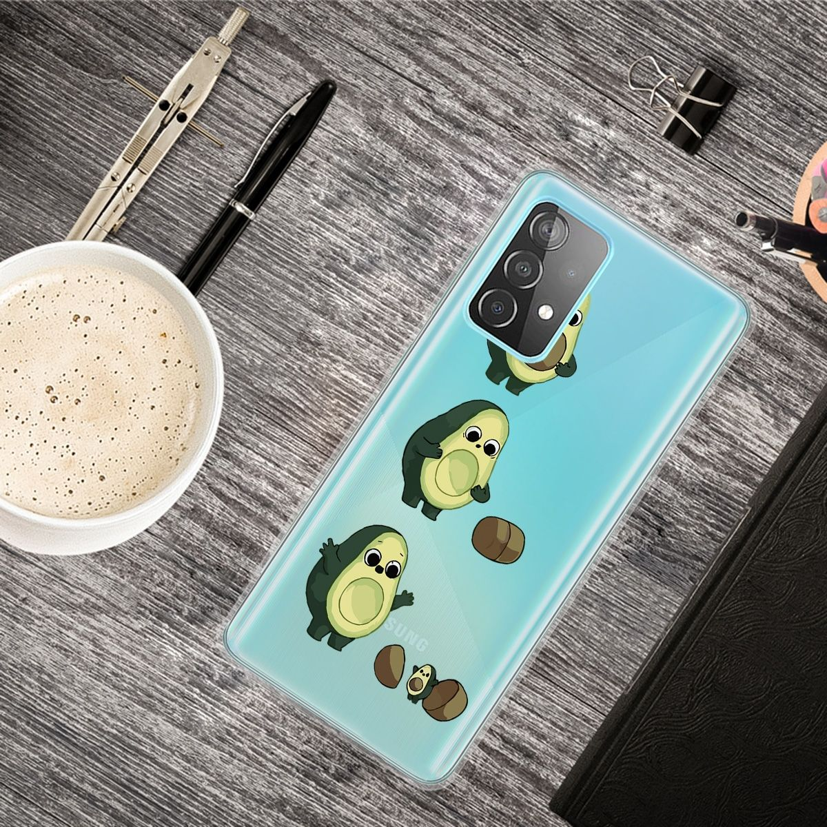 Handyhülle mit Avocado-Cartoonfiguren auf einem Tisch mit anderen Objekten.
