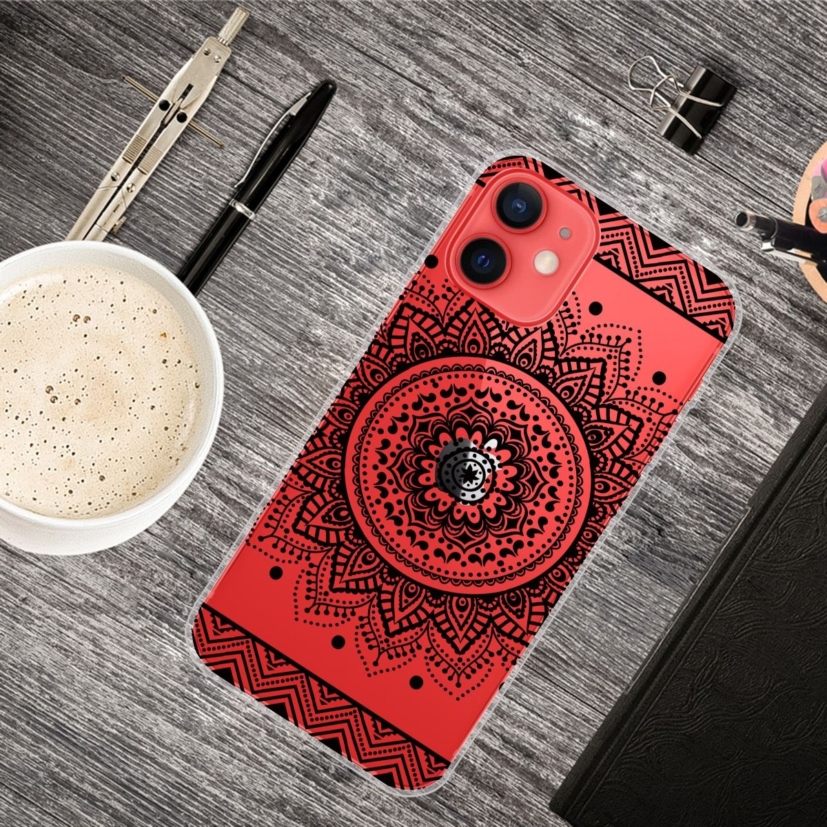 Handyhülle mit rotem Hintergrund und schwarzem Mandala-Design. Es liegt auf einem Holzschreibtisch.