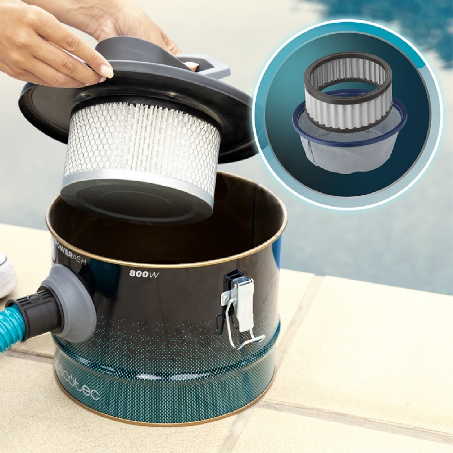 Una persona che rimuove un filtro da un aspirapolvere nero e verde acqua.