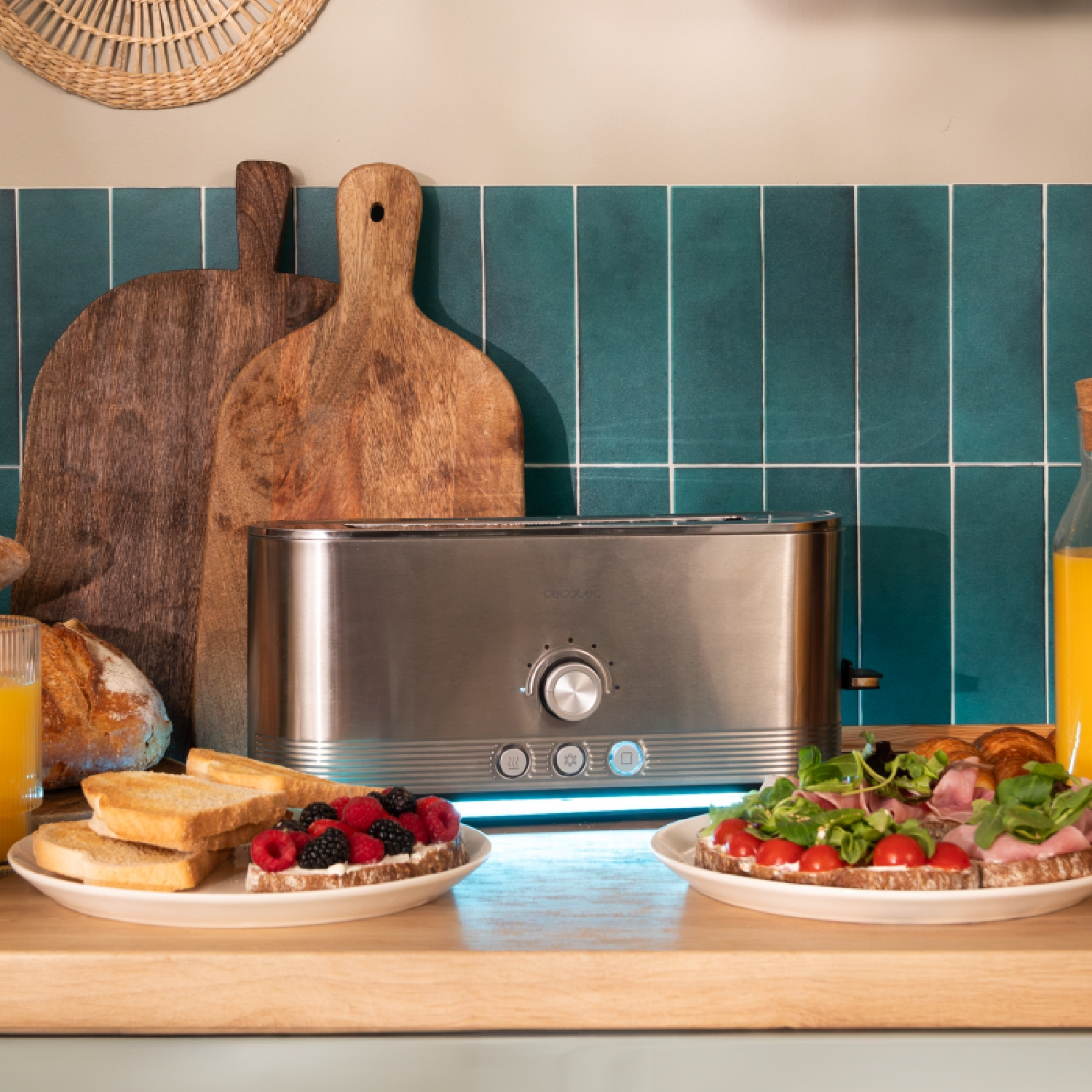 Tostapane argentato con toast, panini e frutta su piatti, su bancone legno.