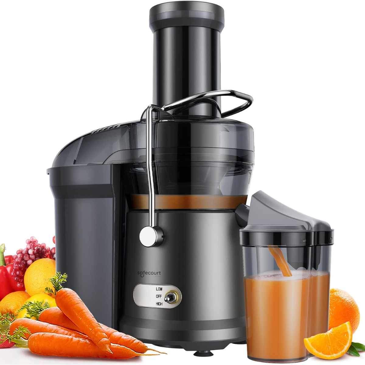 A black juicer with juice pouring into a glass. Vegetables are around.