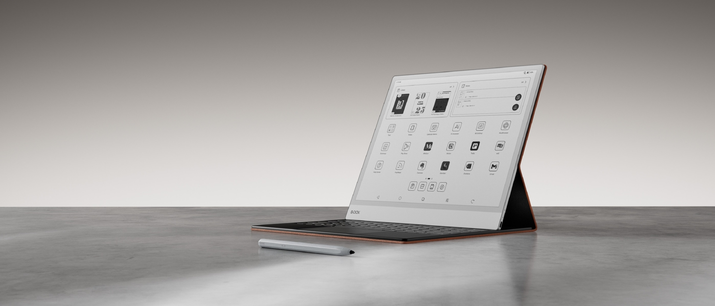 Laptop z interfejsem na ekranie, rysikiem, na szarej powierzchni.