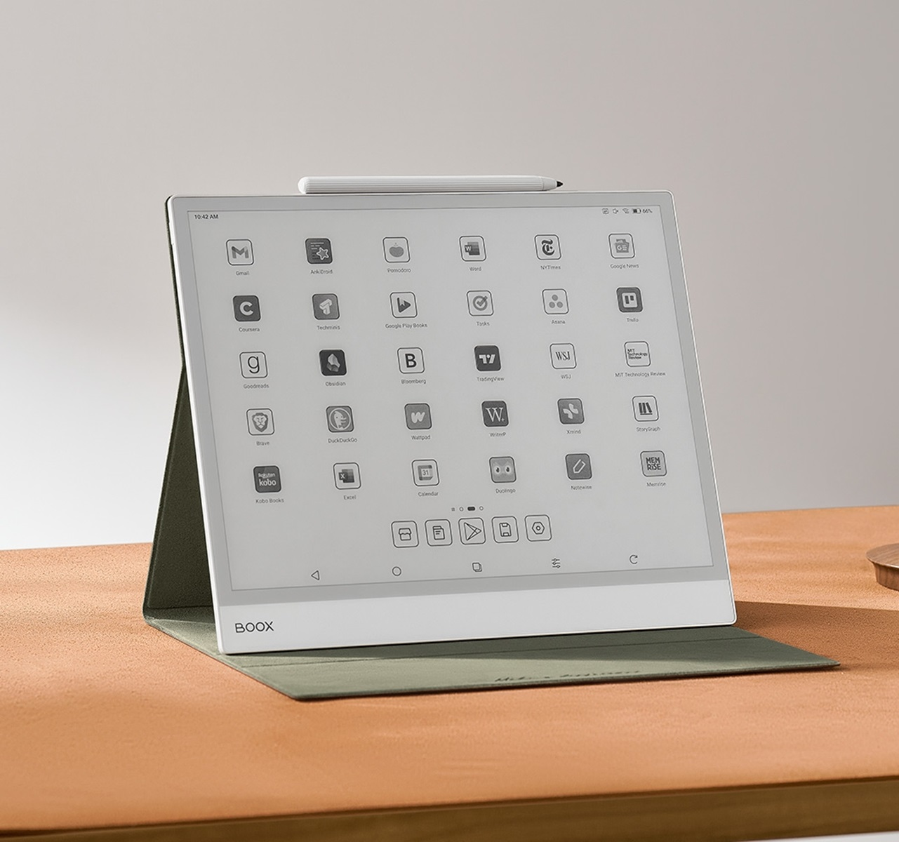 Tablet z piórem na brązowej powierzchni. Na ekranie znajdują się aplikacje.