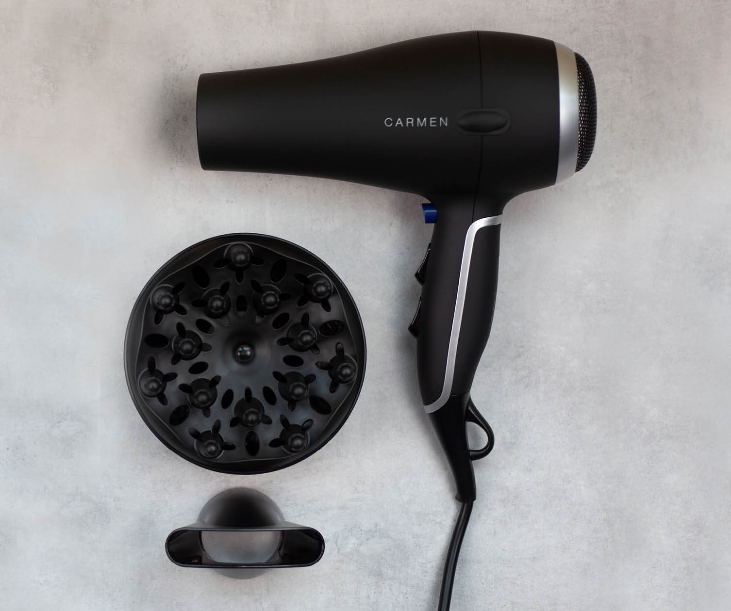 A black Carmen hair dryer with attachments. Isolated on a light gray surface.