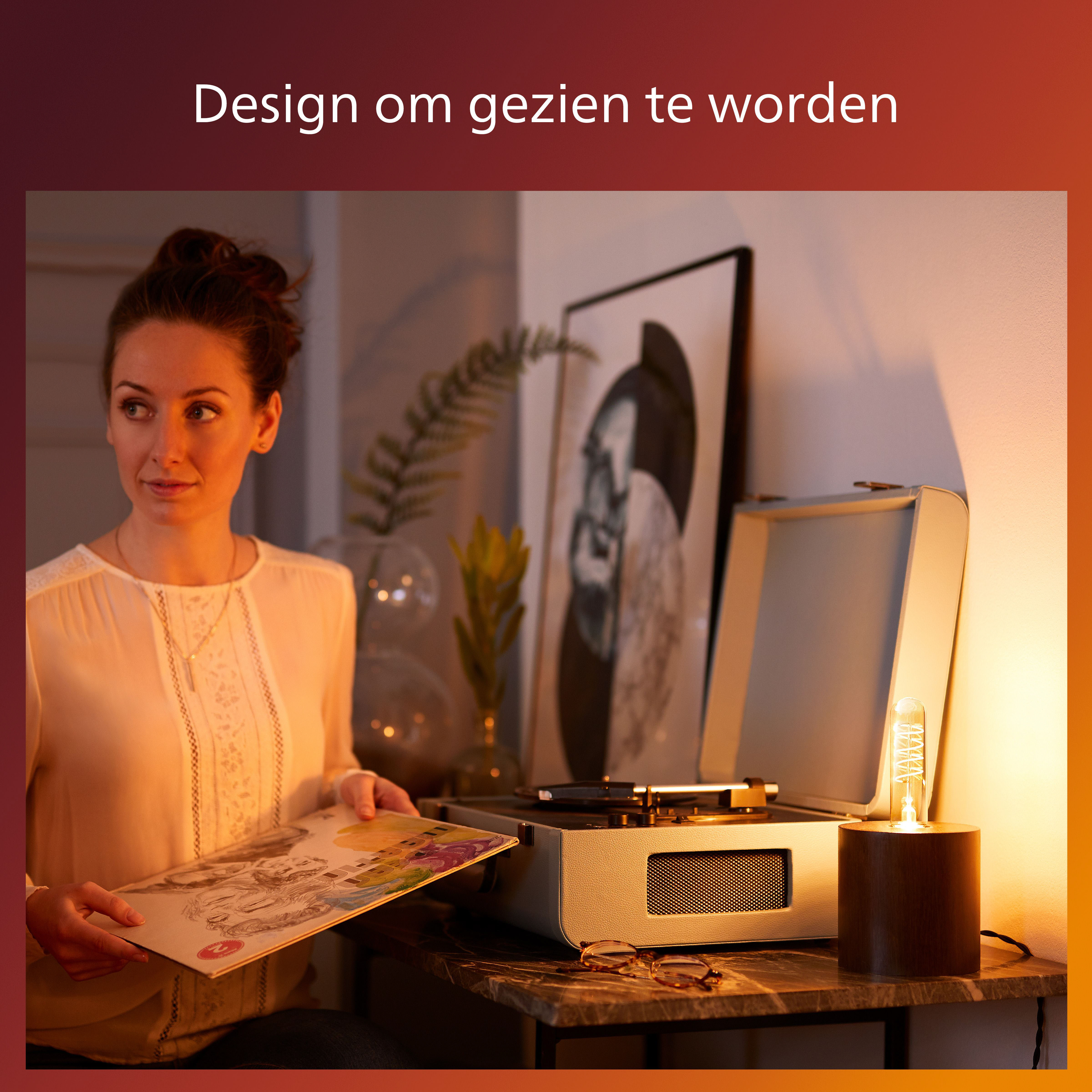 Una donna guarda un vinile vicino a un giradischi con una lampadina LED Philips in un supporto di legno.