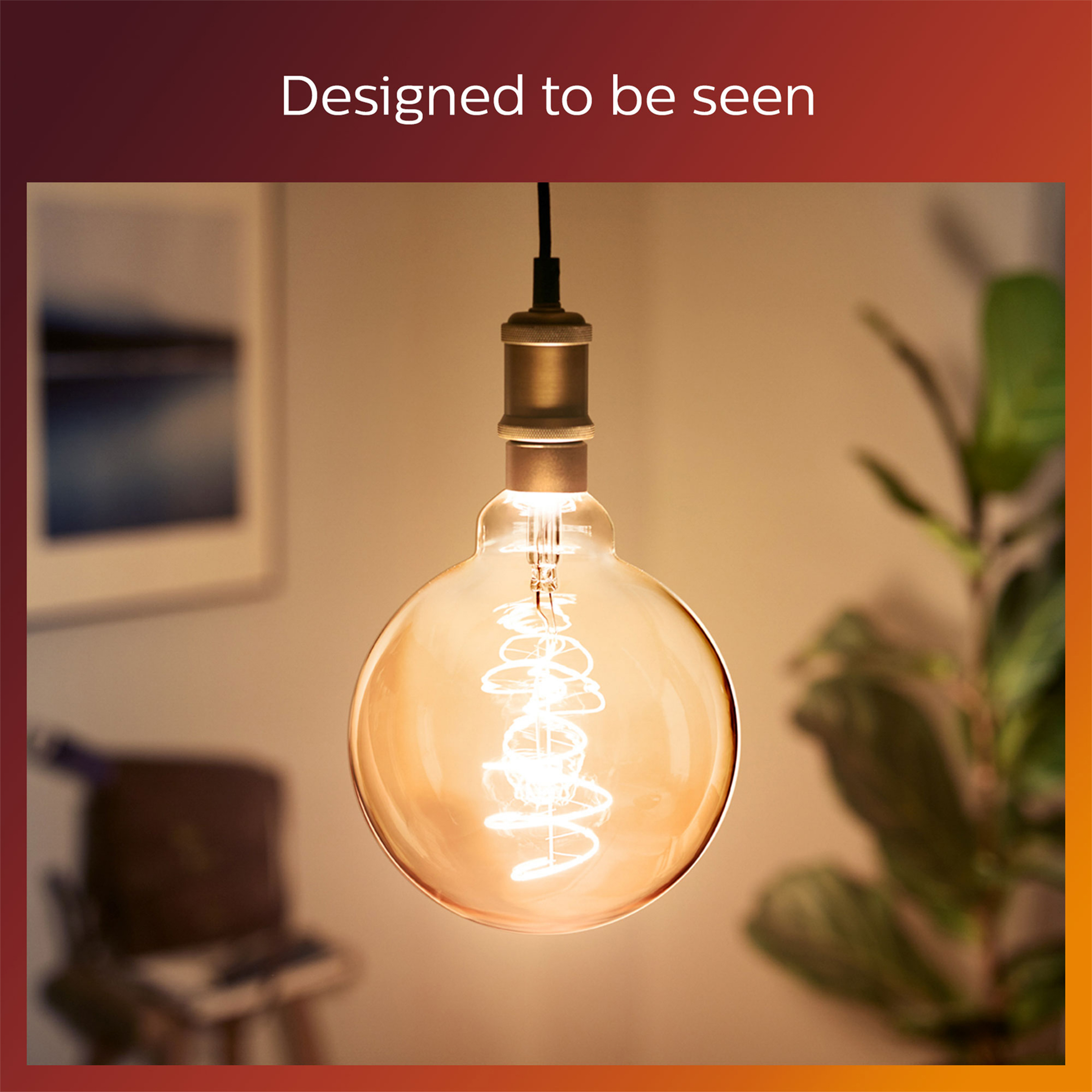 A large, round Philips LED bulb hanging from a ceiling. The bulb is golden.