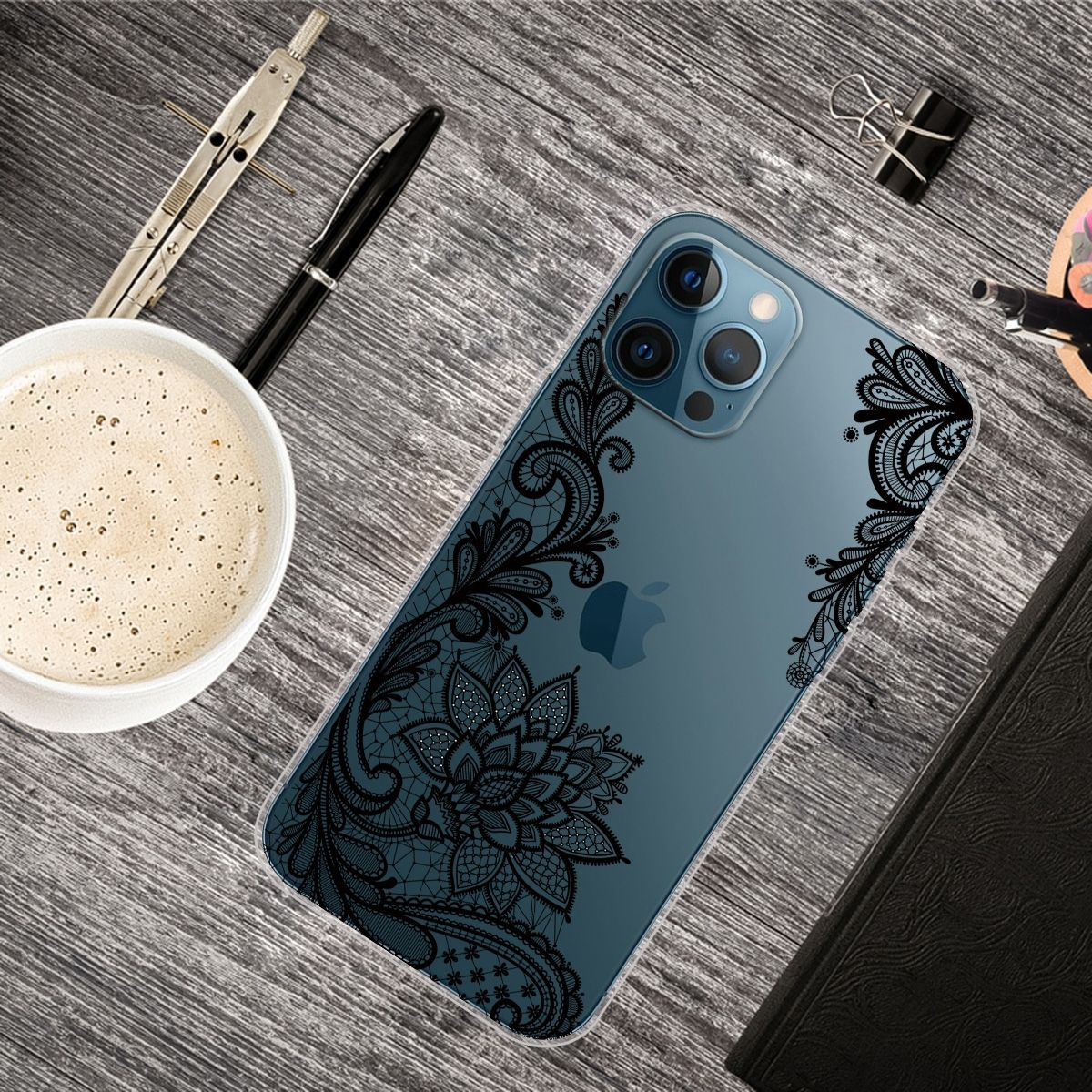 Draufsicht auf ein iPhone in einer transparenten Hülle mit schwarzem Spitzendesign auf Holztisch.