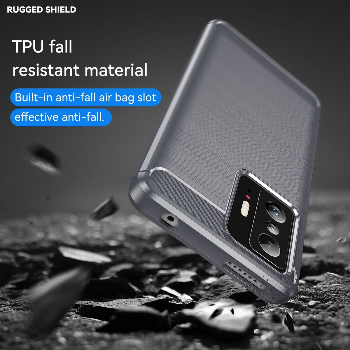 Graue Handyhülle auf strukturierter Oberfläche. Die Hülle hat einen Kameraausschnitt und trägt die Aufschrift 'Rugged Shield'.