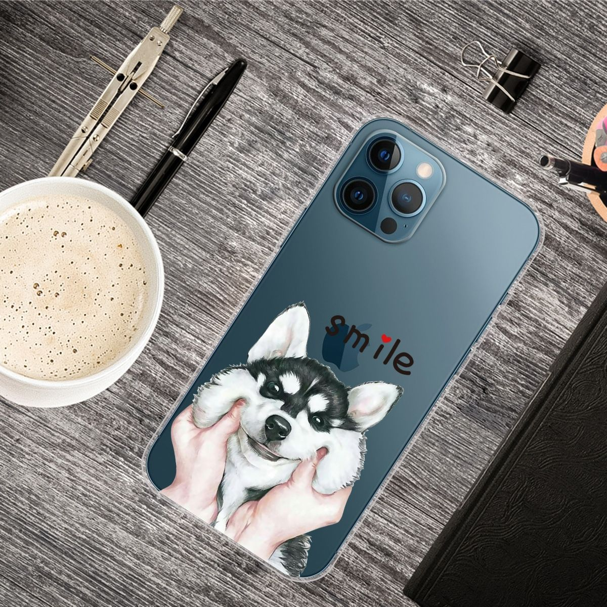 Handyhülle mit Husky-Gesicht. Kaffeetasse, Stifte und Notizbuch liegen auf dem Schreibtisch.
