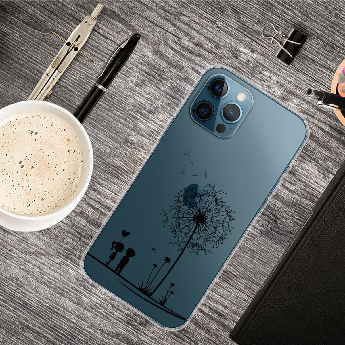 Handyhülle auf einem Holztisch mit Kaffee, Stift und anderen Gegenständen. Löwenzahndesign.