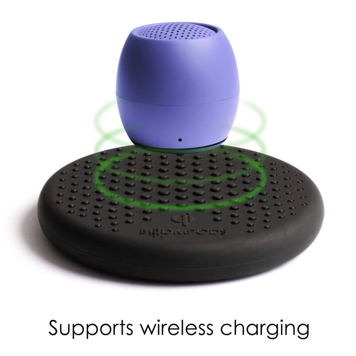 Mały fioletowy głośnik na czarnej podstawie ładującej. Tekst brzmi 'Supports wireless charging'.