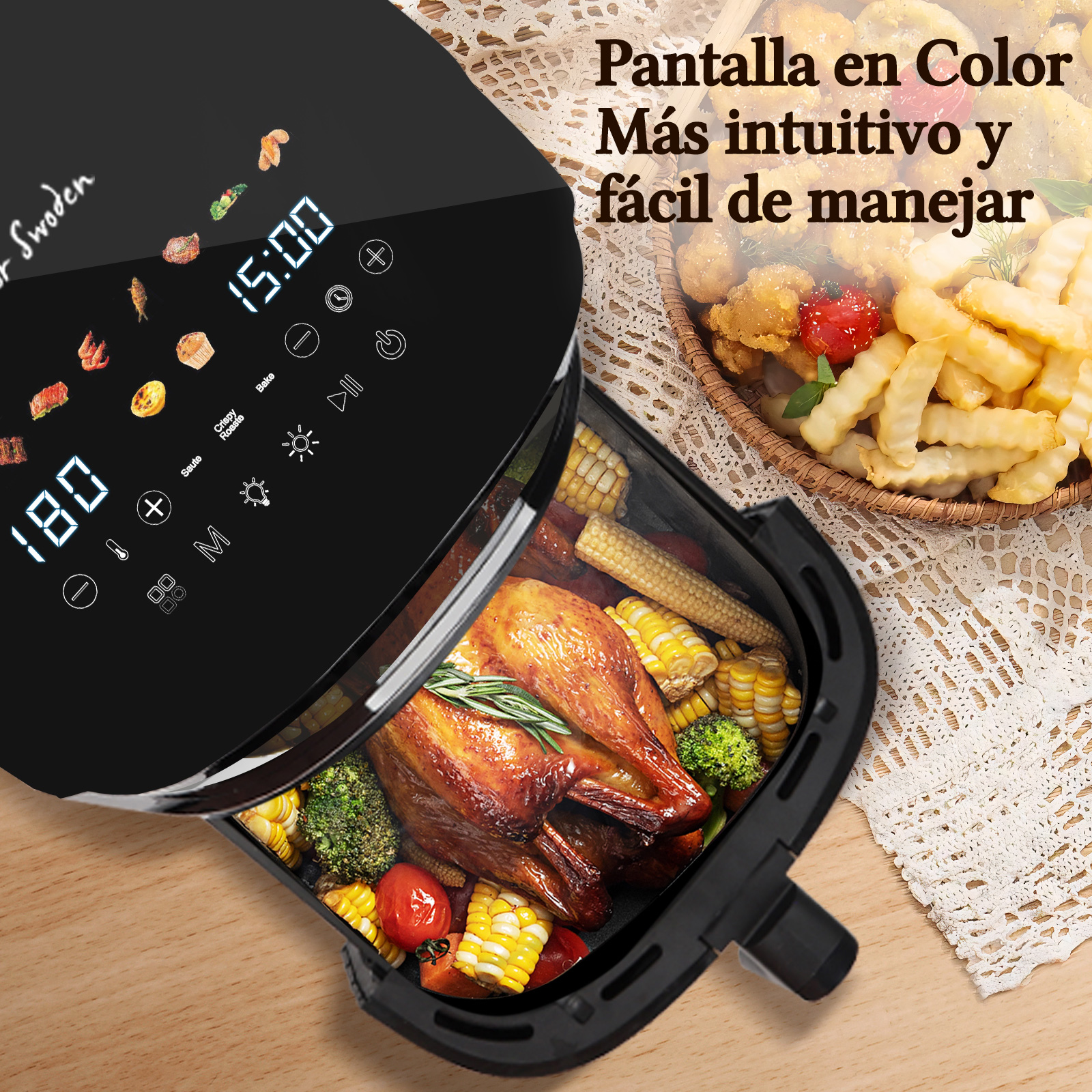 Una freidora de aire negra abierta con comida cocinada dentro y una cesta de patatas fritas en la mesa.