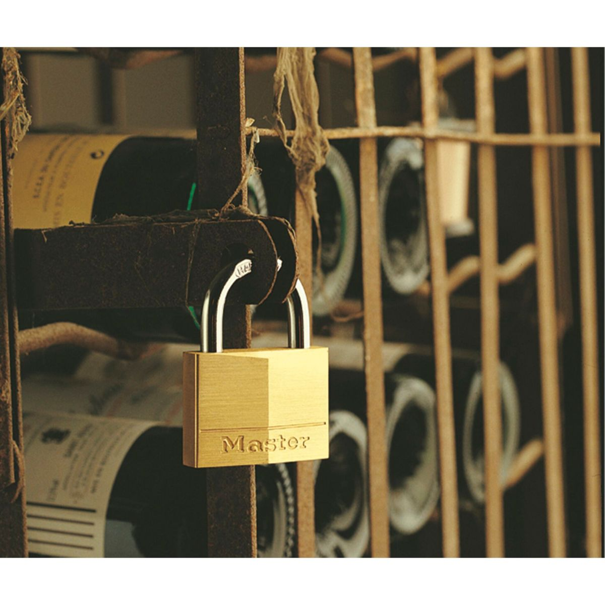 Goldenes Master-Vorhängeschloss an einem Weinregal.