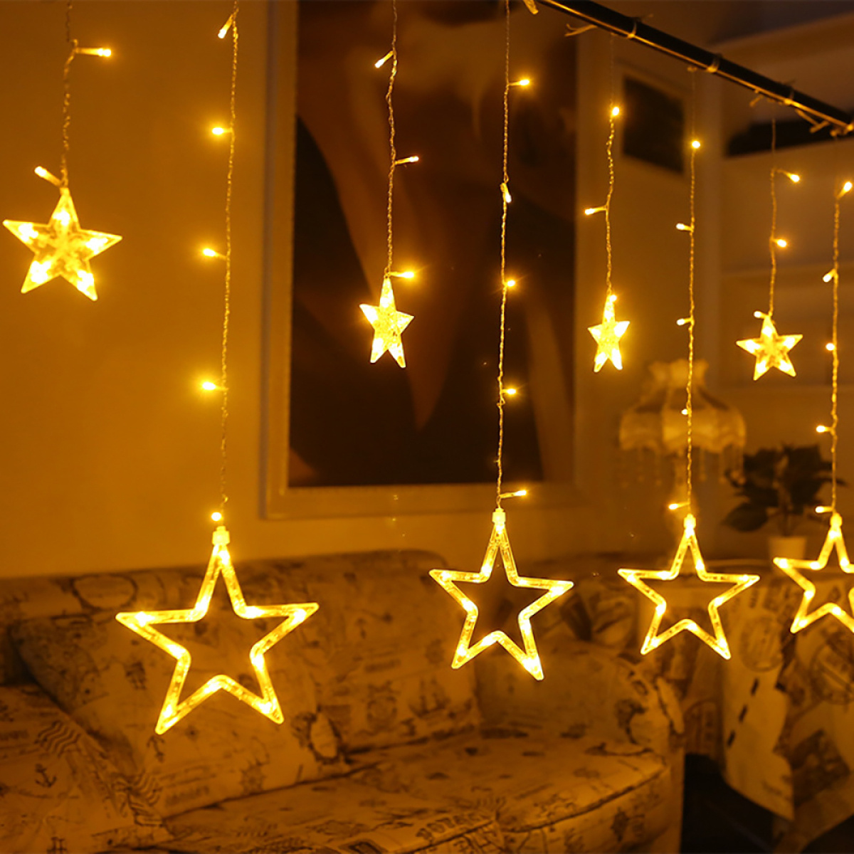 Sternförmige Lichterketten hängen. Sie sind gelb, mit vielen Lichtern im Hintergrund.