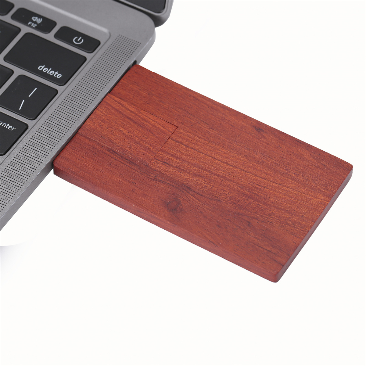 Roter USB-Stick aus Holz in einem Laptop, zeigt den Stick und Teile des Laptops.