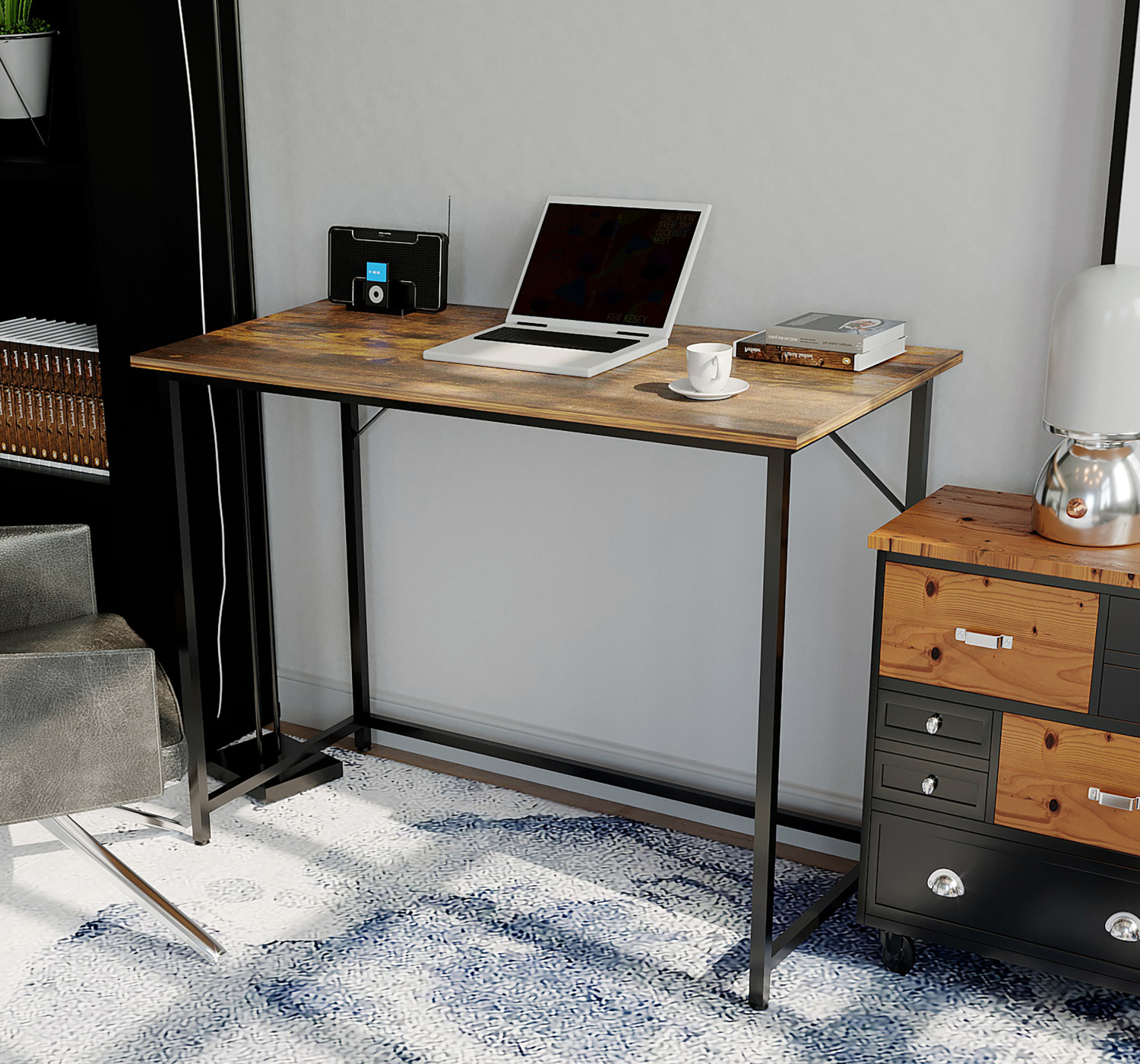 Een houten bureau met een laptop, boeken, een radio en een koffiekopje. Het bureau heeft zwarte metalen poten.