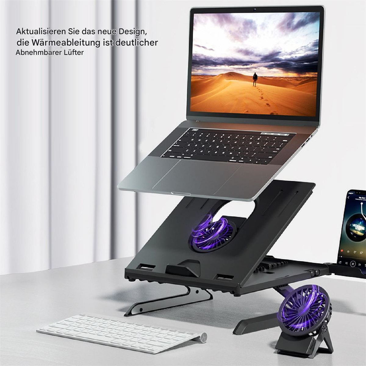 Laptop auf Ständer mit Lüfter, Tastatur und Telefon. Der Hintergrund zeigt eine Wüstenlandschaft auf dem Laptop.