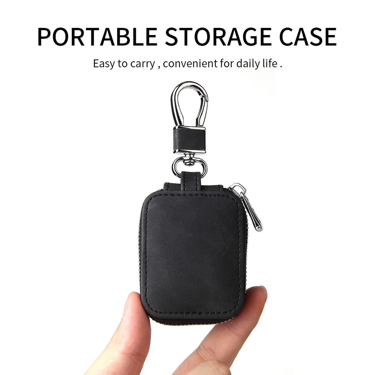 Eine kleine schwarze Ledertasche für Schlüssel wird mit einem Haken gezeigt. Eine Hand hält die Tasche.