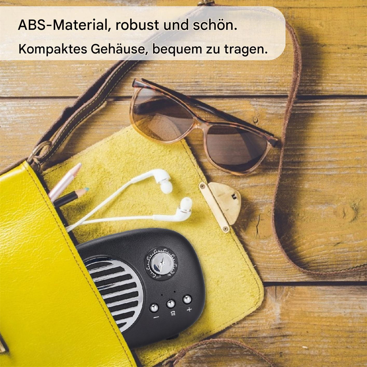 Schwarzes Retro-Radio in einer gelben Tasche. Sonnenbrille und Kopfhörer sichtbar.