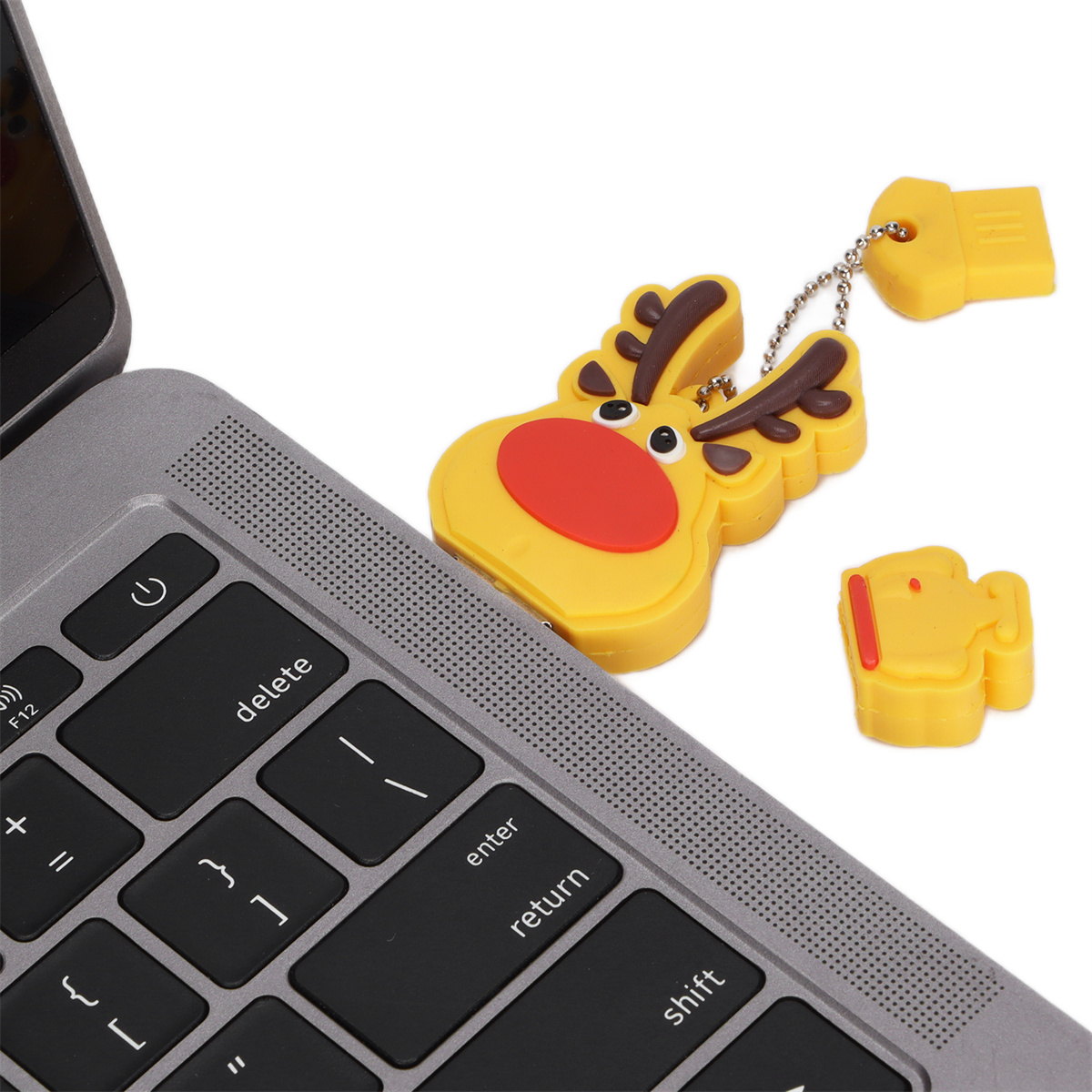 Laptop-Tastatur mit einem gelben Rentier-USB-Stick und einem gelben USB-Anschluss.