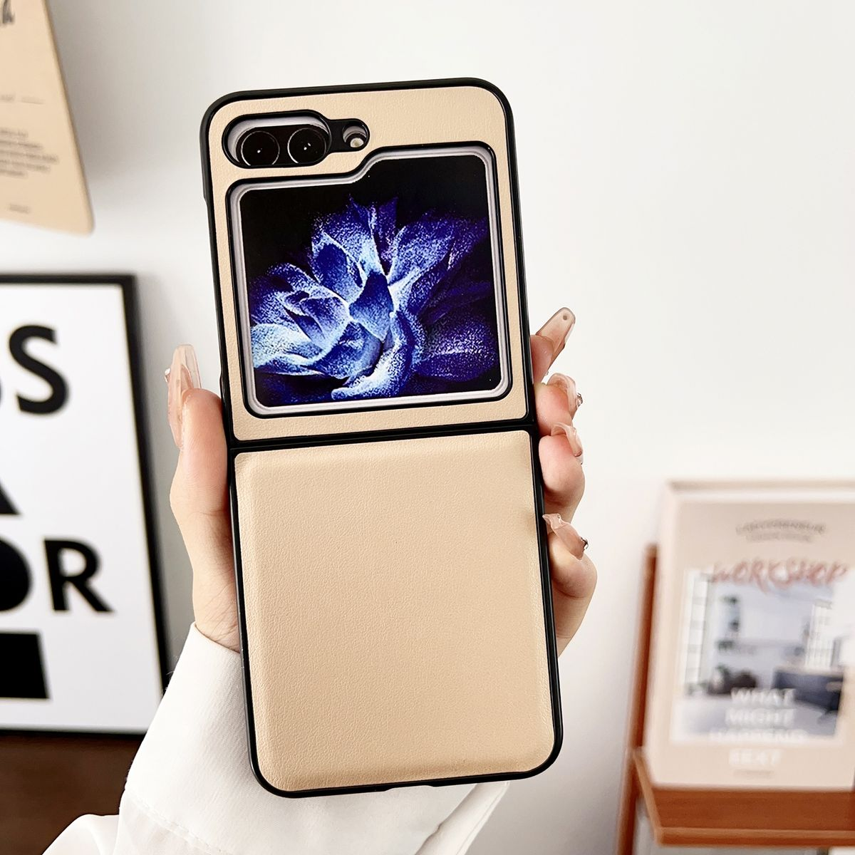 Hand hält eine beige Handyhülle. Das Telefon zeigt ein blaues Blumenmuster.