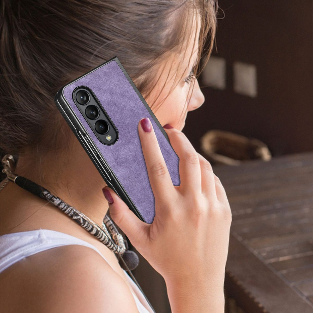 Hand einer Frau, die eine lila Handyhülle hält. Telefon ist nicht sichtbar.