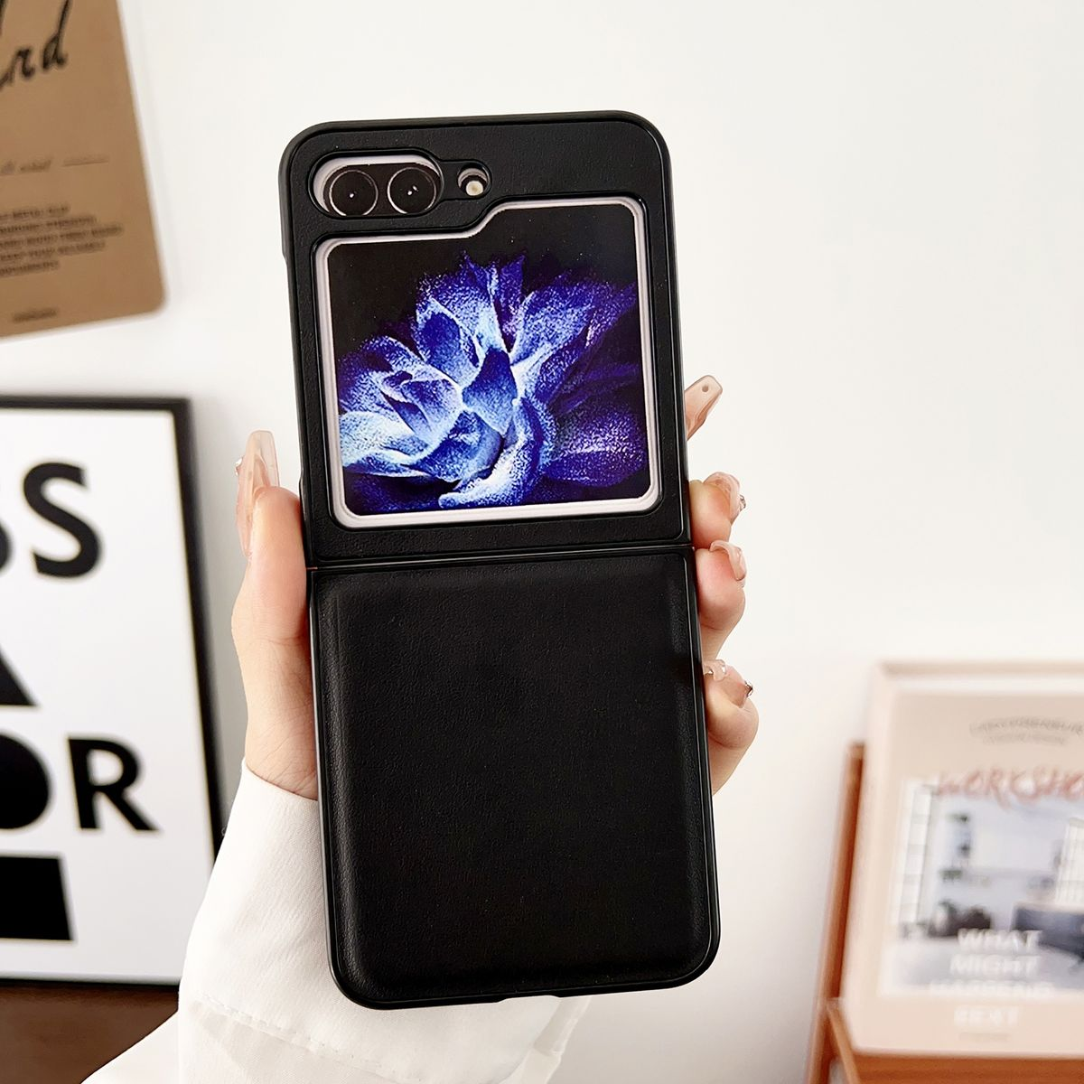 Schwarzes faltbares Telefon in einer Hülle, gehalten von Hand.