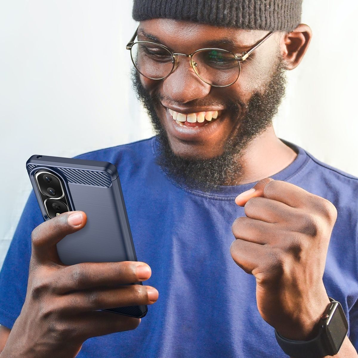 Mann mit Brille hält Telefon in Hülle, lächelt, mit Uhr, auf weißem Hintergrund.
