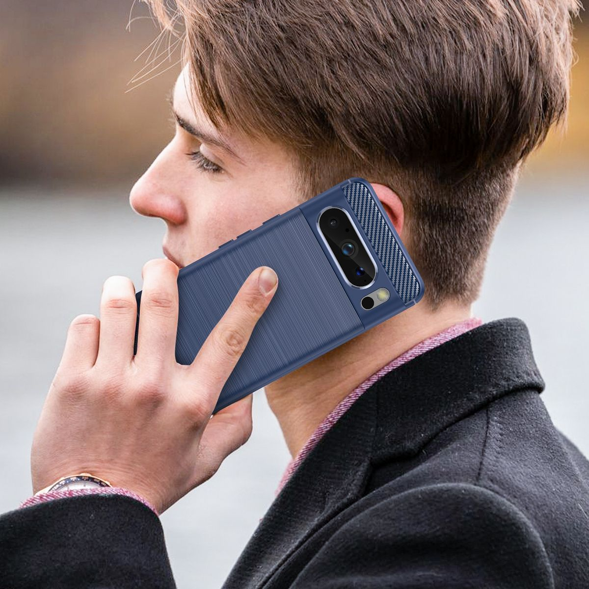 Ein Mann hält ein blaues Telefon und telefoniert. Die Handyhülle hat eine strukturierte Rückseite und Kohlefaserakzente.