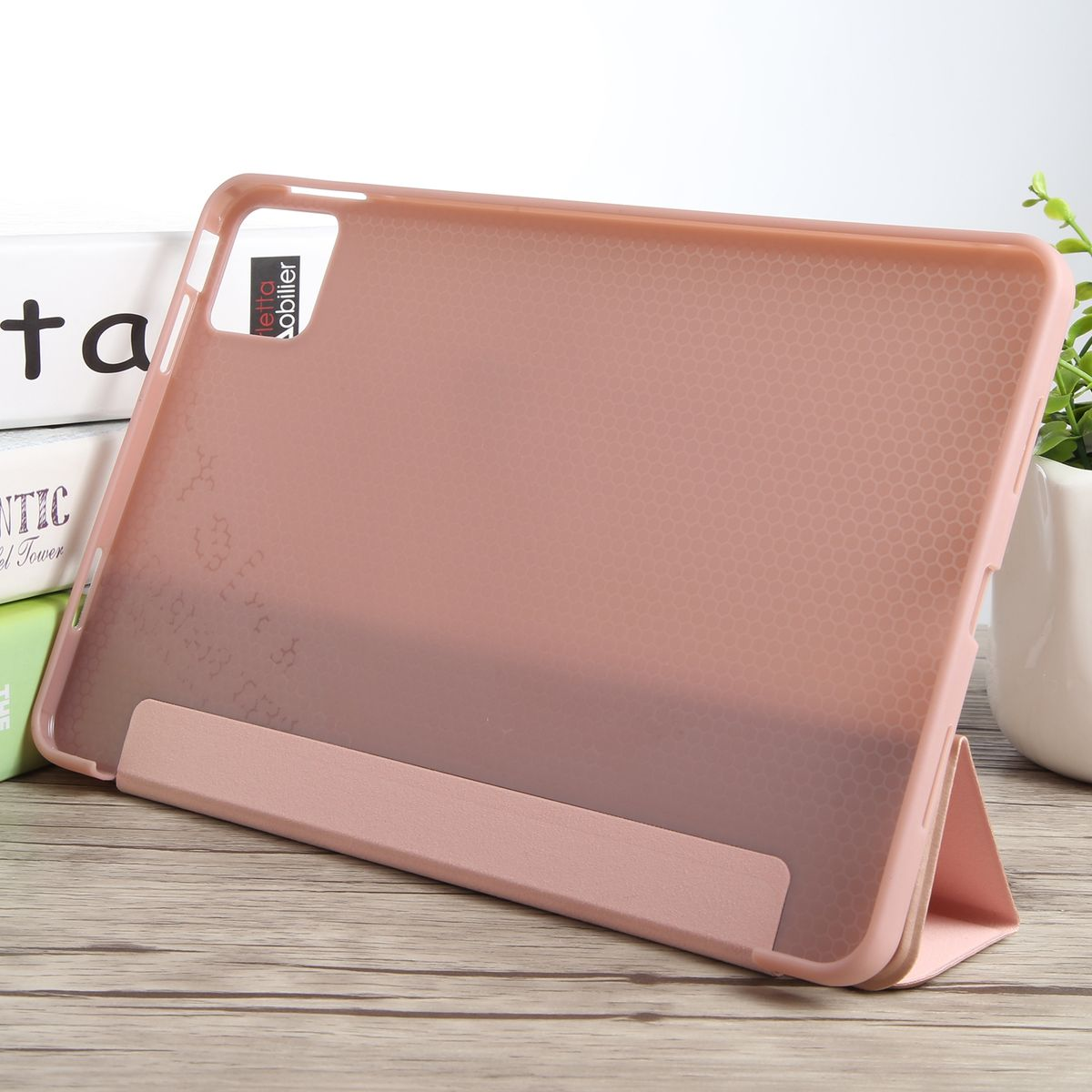 Rosa Tablet in einer Hülle, die auf einer Holzoberfläche steht.